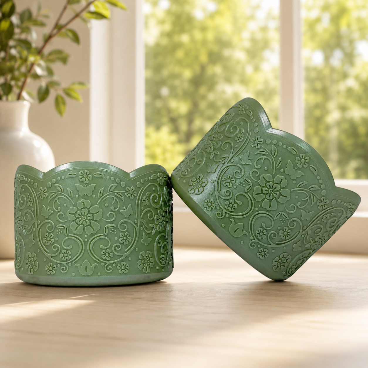 Patricia shimmer leafy green silicone tumbler boots, a pair on a wood table showing the vintage floral embossing and scalloped edge.